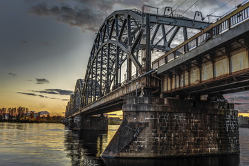 Fototapeta premium View of the railway bridge across the Daugava River during the sunset in Riga