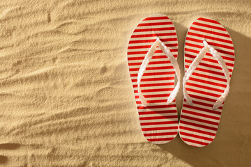 Flip flops on a sandy beach, sunset, top view