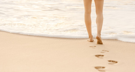 Woman's feet walking on beautiful white sand beach. Beach holiday. 