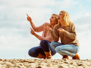 Women on beach having fun pointing