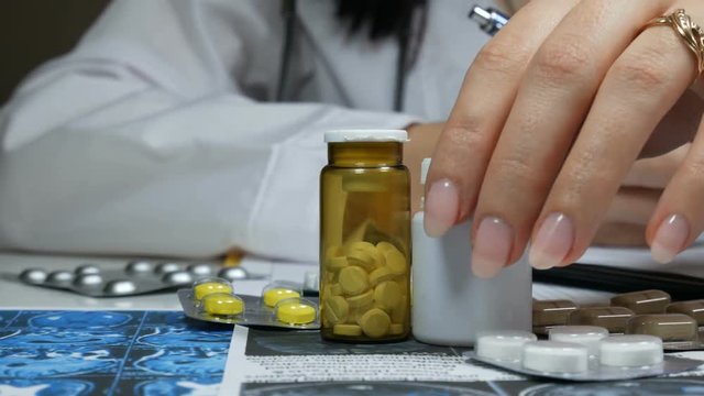 woman doctor working at the table with different pills