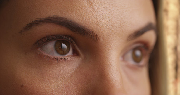 Close up of female millennial's eyes blinking outdoors