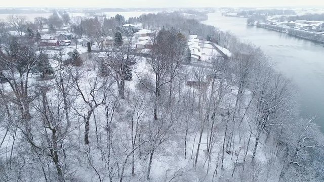 Idyllic snow covering scenic riverside trees and homes, aerial view during snow storm, Wrightstown, Wisconsin. 