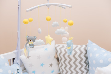 Baby mobile with different toys in the form of animals and stars, felt toys in crib