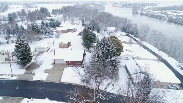 Idyllic snow covering scenic riverside trees and homes, aerial view during snow storm, Wrightstown, Wisconsin. 