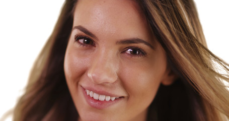 Close-up of pretty millennial girl smiling at camera on white background with copyspace