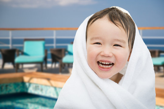 Happy Cute Mixed Race Chinese and Caucasian Boy On Cruise Ship Wrapped In A Towel