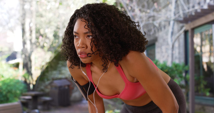 Determined black girl in workout attire getting ready for her morning jog - Powered by Adobe