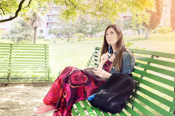 Young woman in the park sitting on a bench