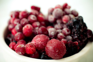 Bright, delicious, frozen, colored, berries, blueberries and cranberries on a white plate