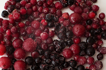 Bright delicious frozen colored blueberry cranberries on white background