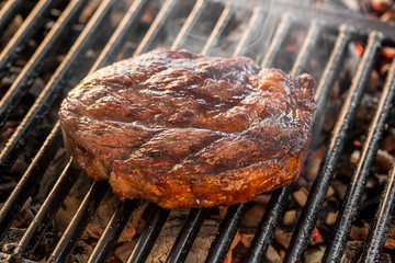 Big marbled Beef steak on the grill with flames