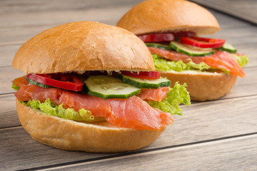 Sandwich with red fish and vegetables, on a wooden background. Concept of healthy food, diet.