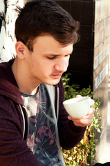 a young guy tries coffee on the palate in the street coffee shop espresso dopio