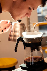 the barista sniffs at the smell alternative way of brewing coffee in the coffee shop hario v60 soft light