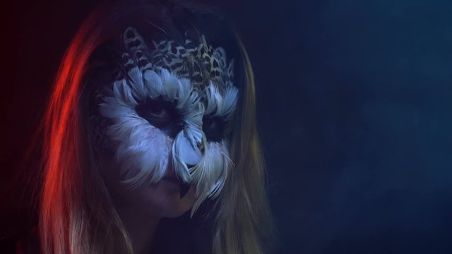 Close-up, Beautiful Girl with Owl Face Mask on Face Simulates Blinking Eyes as a Bird