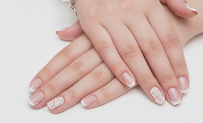 Manicure with rhinestones in the shape of hearts and pink balls on white and red nail Polish on a white background.