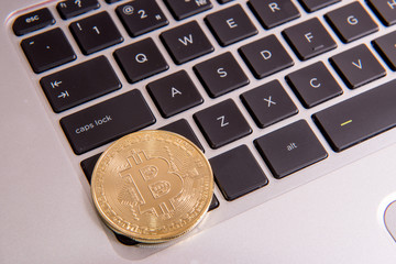 Cryptocurrency physical golden bitcoin coin on keyboard