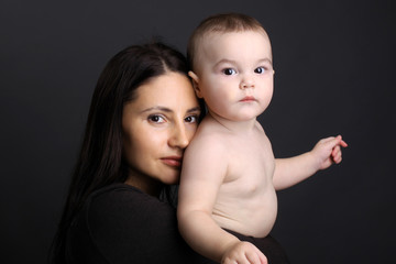 Beautiful mother holding a serious child in her arms