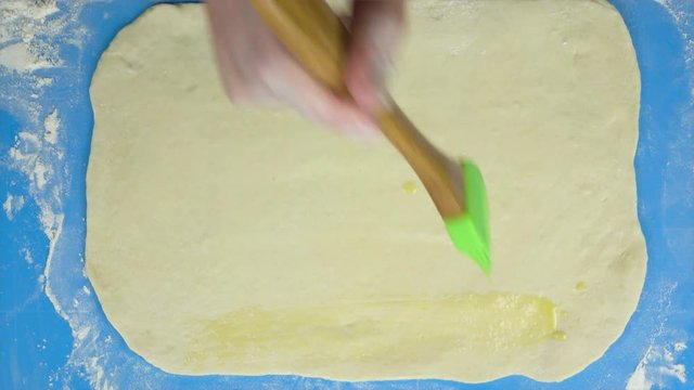 4K footage. Baker hand smears an egg dough. Top view