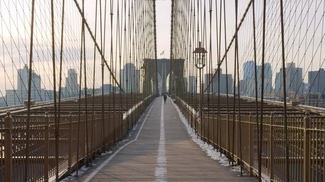 Static view on top of the Brooklyn Bridge with people on the path.