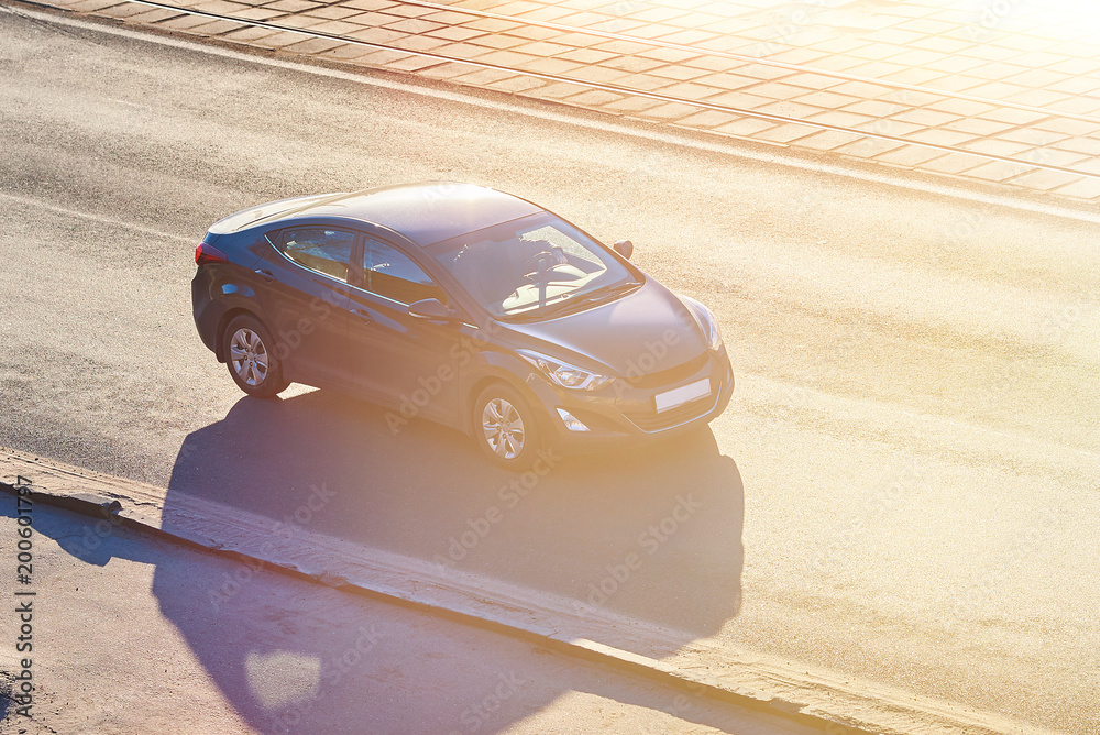 Wall mural Black passenger car in the sun