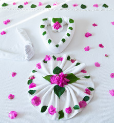 Bed in hotel decorated with flowers and towels