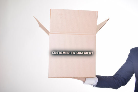 The businessman is holding a box with the inscription:CUSTOMER ENGAGEMENT