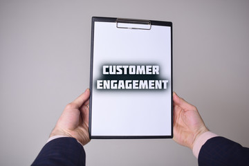 A businessman shows an inscription:CUSTOMER ENGAGEMENT