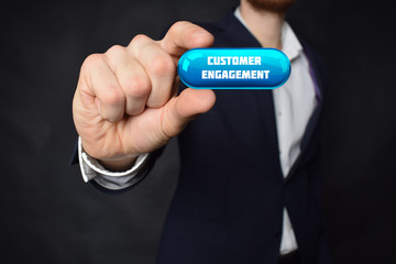 A businessman shows an inscription:CUSTOMER ENGAGEMENT