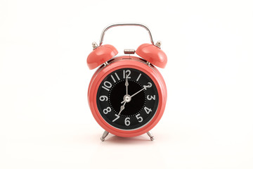 Red vintage alarm clock on white background.