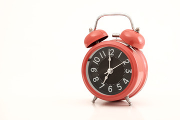 Red vintage alarm clock on white background.