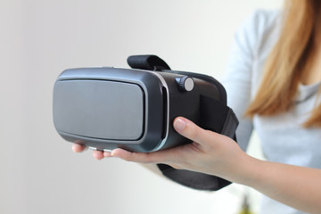 Young woman wearing virtual reality glasses at home.
