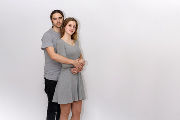 young and beautiful man and woman are standing on white background in different poses