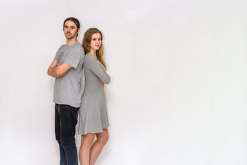 young and beautiful man and woman are standing on white background in different poses