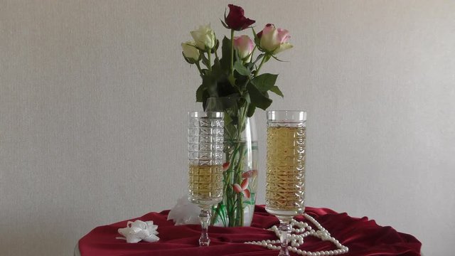 Still life of wedding wine glasses and a bouquet of roses