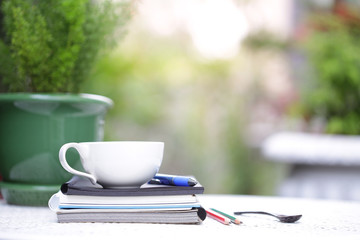White cup and notebooks at outdoor