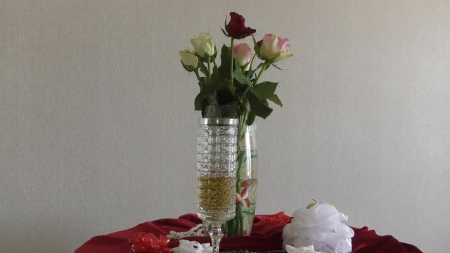 Still life of wedding wine glasses and a bouquet of roses