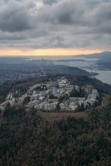 Striking Aerial view of Burnaby Mountain during a  dramatic cloudy sunset. Taken in Vancouver, British Columbia, Canada.