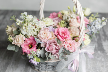 Beautiful flower composition a bouquet in a wicker basket. Floristry concept. Spring colors