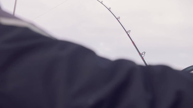 Hand of yachtsman trolling fish from biard of yacht