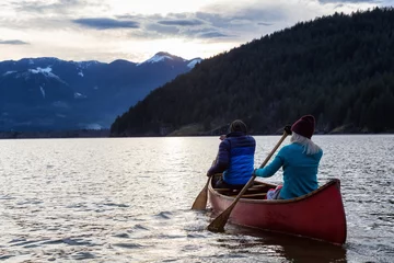 Foto op Canvas Adventurous people on a wooden canoe are enjoying the beautiful Canadian Mountain Landscape during a vibrant sunset. Taken in Harrison River, East of Vancouver, British Columbia, Canada. © edb3_16