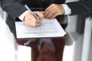 Close-up of female hands with pen over document,  business concept