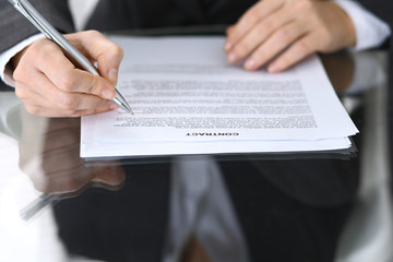 Close-up of female hands with pen over document,  business concept