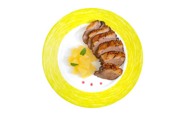 Duck breast Magret with pieces of pineapple on a plate isolated on white background. French traditional meat dish. Christmas menu. Festive kitchen.