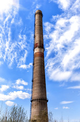 Factory plant smoke stack over blue sky background. Energy generation and air environment pollution industrial scene.
