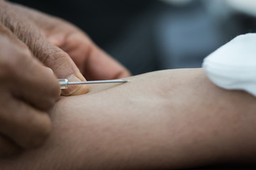Health and Medical concept. Closeup Hands nurse are using needle to pierce vein Preparation for blood test on table. Blood donation occurs when person voluntarily has blood drawn used for transfusions