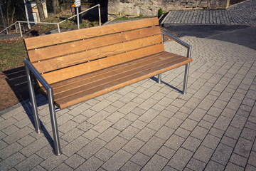 Wooden modern bench in the city with iron racks