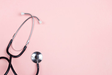 Top view of stethoscope on pink background. Flat lay and copy space.
