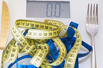 scales and metric tapes with steel cutlery. diet and slimming concept